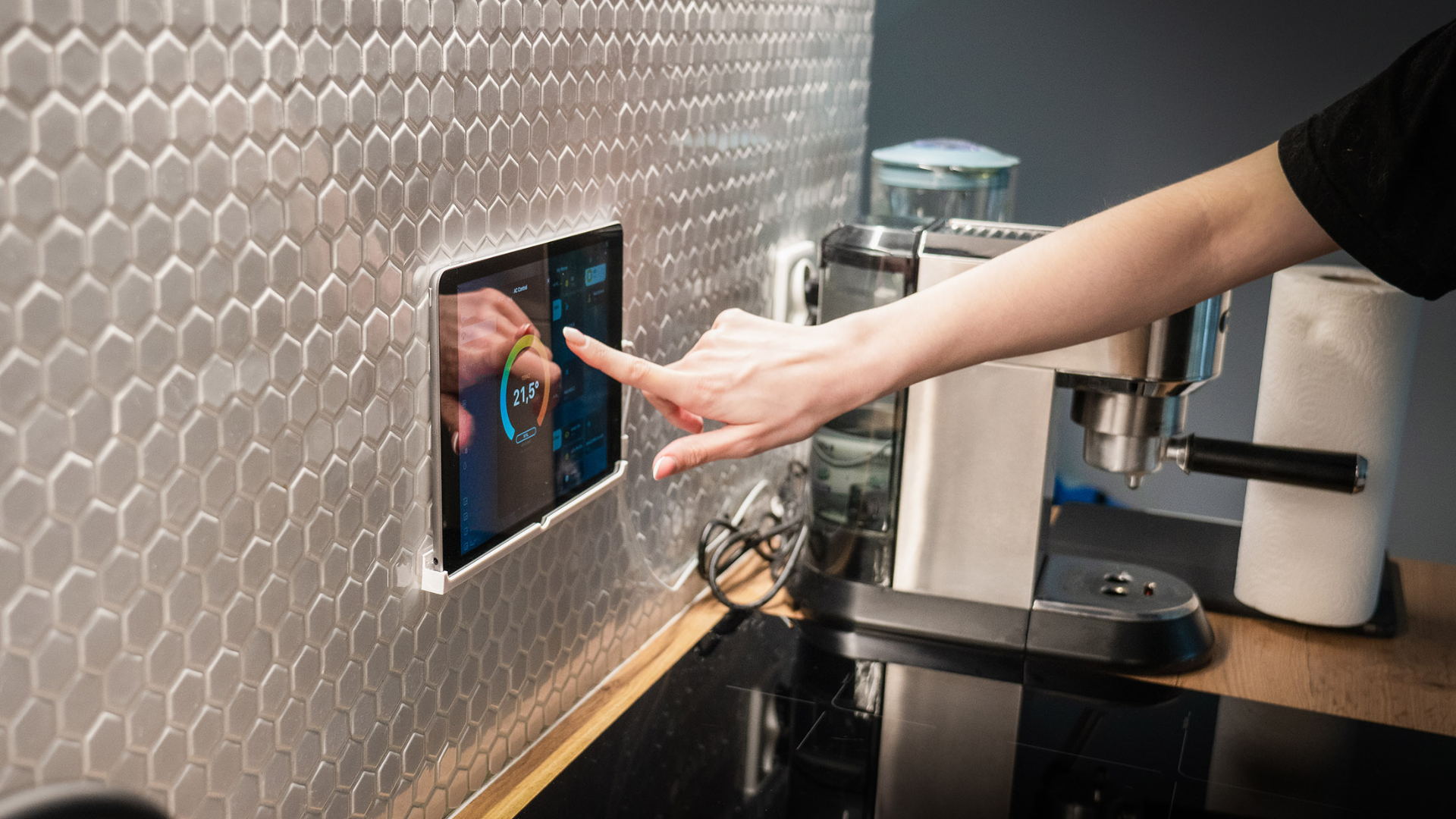 A person adjusting the smart thermostat screen on the wall.